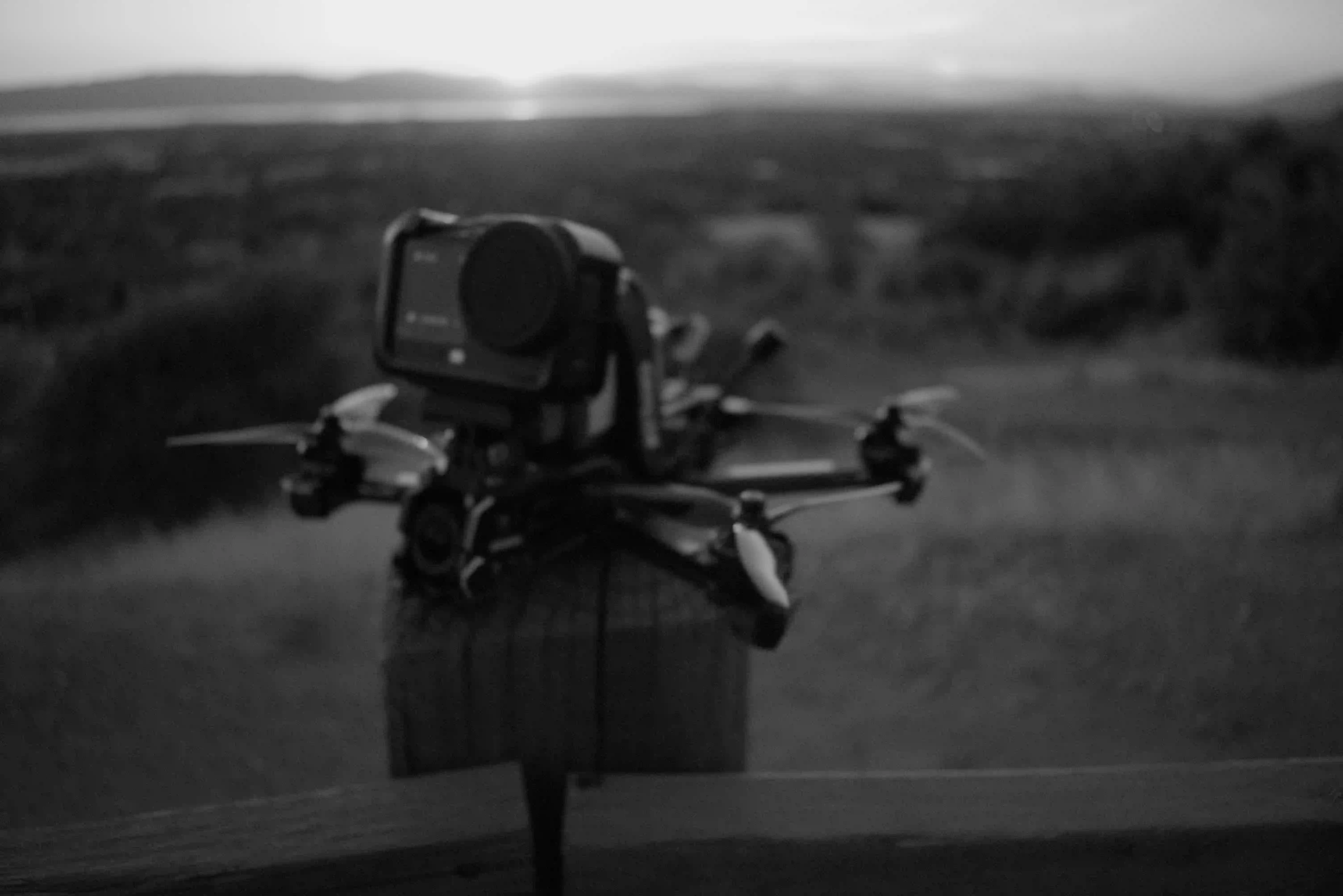 Custom FPV drone silhouetted against a green sky